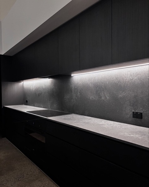 Under cabinet strip lighting along a dark stone benchtop