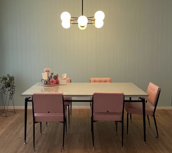 A dining room lit by a warm ceiling chandelier