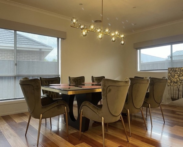 A dining table under a multi arm ceiling light