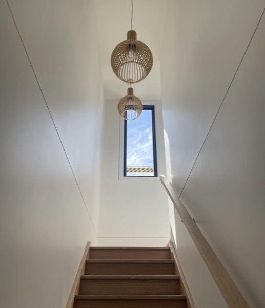 Pendant lights hanging above a timber staircase