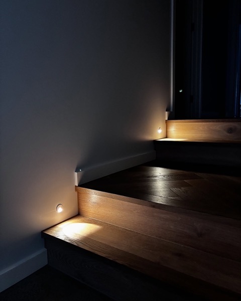 A recessed step light beside a timber stair tread