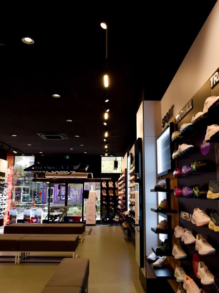 A retail fitout with track lighting and lit wall shelving