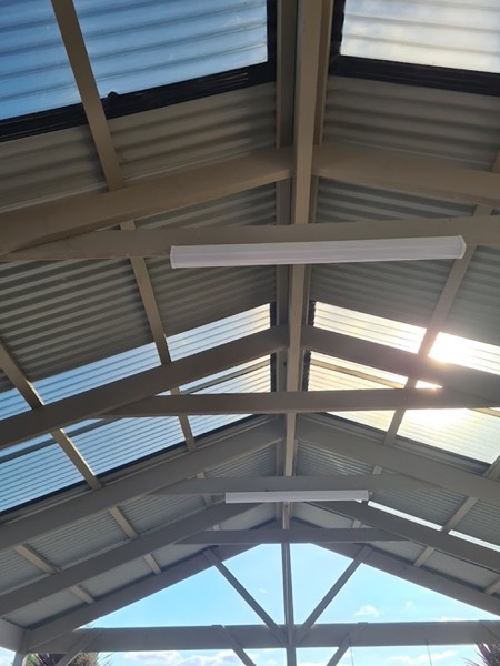 A pitched verandah roof with a skylight and mounted lights